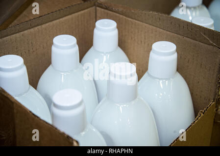 Verpackung von kosmetischen Spray aus Aluminium und Kunststoff Flasche Kappen auf der Ansicht von oben, viele Shampoo Flaschen im Karton Stockfoto