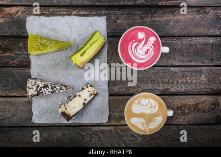 Ansicht von oben Latte Art mit zwei Arten von käsekuchen auf Holztisch, Coffee shop Hintergrund. Stockfoto