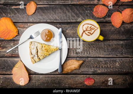 Apfelkuchen mit Besteck und Kaffee auf einem weissen Teller, auf einer schönen Holz- Hintergrund. Ansicht von oben Stockfoto