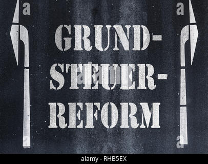 Deutsche Wort Grundsteuerreform (Anwesen oder Grundstücken Steuerreform) auf Asphalt geschrieben Stockfoto