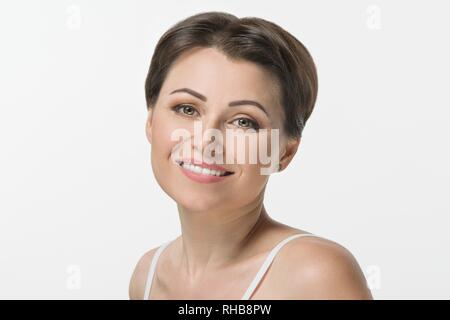 Nahaufnahme eines schönen Mitte der erwachsenen Frau lächelnd auf weißem Hintergrund. Stockfoto