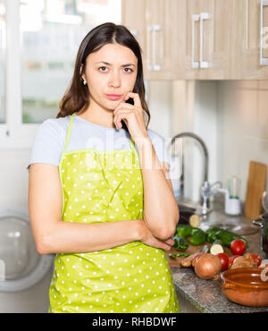 Junge Mädchen Hausfrau in der Schürze in der Küche zu Hause müde Stockfoto