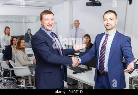 Junge Unternehmer zufrieden die Hände schütteln, während Sie schlichten Treffen, die Vereinbarung Stockfoto