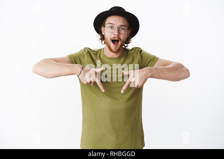 Taille - geschossen von gewundert und stattlichen hipster Kerl Gefühl begeistert und neugierig wie unten mit erhobenen Zeigefinger Fragen stellen erstaunt Stockfoto