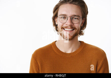 Nahaufnahme der charmante charismatische Art und glücklichen Mann mit Bart und Brille in warmen Pullover weitgehend an Kamera Gefühl unbeschwert Lächeln und Stockfoto