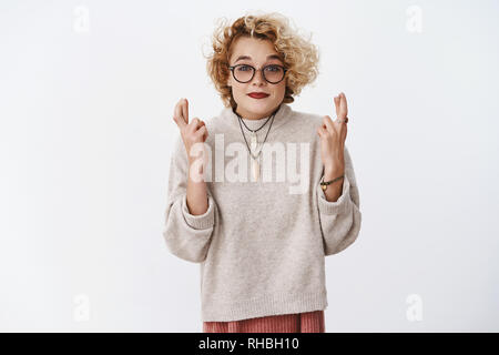 Hoffnungsvoll und optimistisch nette junge Europäische Weiblich mit kurzen stilvolle Frisur und Brille lächelnd niedlich und aufgeregt als die Daumen für gute Stockfoto