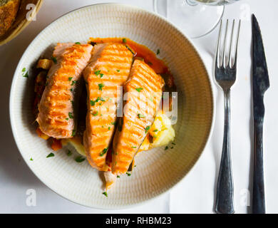 Lachs auf dem Grill, mariniert in Soße, Dill, Salz, Pfeffer und ein paar Tropfen Zitrone, serviert mit Kartoffeln Stockfoto