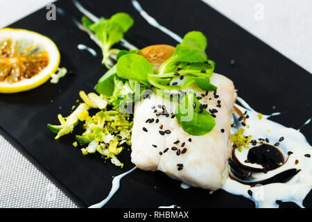 Rezept der französischen Stil cod: Eintopf 250 g Kabeljaufilet mit Weißwein, Sahne, schwarzer Pfeffer und Provence Kräuter für 20 Min. Dienen mit gebackenen Kartoffeln, Salat Stockfoto