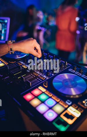 DJ spielt live und Mischen von Musik auf Drehsockel Konsole im Stadium der Night Club. Disk Jokey Hände auf einem Mischpult Station im Club Party. DJ-Mixer Stockfoto
