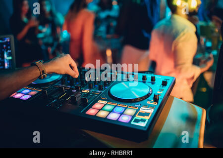 DJ spielt live und Mischen von Musik auf Drehsockel Konsole im Stadium der Night Club. Disk Jokey Hände auf einem Mischpult Station im Club Party. DJ-Mixer Stockfoto