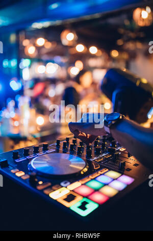 DJ spielt live und Mischen von Musik auf Drehsockel Konsole im Stadium der Night Club. Disk Jokey Hände auf einem Mischpult Station im Club Party. DJ-Mixer Stockfoto