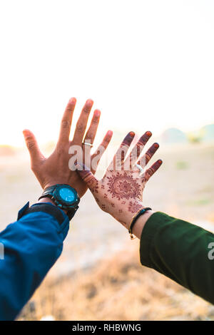 Hände hoch auf Weiterleiten. Junge und glückliche Paare halten sich an den Händen. Mann oder Junge und Mädchen hielten ihre Hände. Han's Das Mädchen hat Henna. Asiatische paar Liebe jedes o Stockfoto