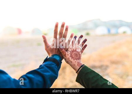 Hände hoch auf Weiterleiten. Junge und glückliche Paare halten sich an den Händen. Mann oder Junge und Mädchen hielten ihre Hände. Han's Das Mädchen hat Henna. Asiatische paar Liebe. Stockfoto