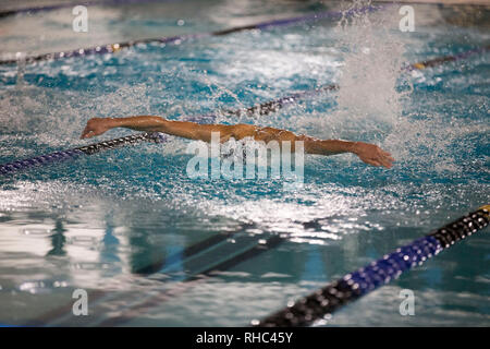 Schwimmer, die bei einem Schwimmtreffen an einem Schmetterlingsschlag teilhat Stockfoto