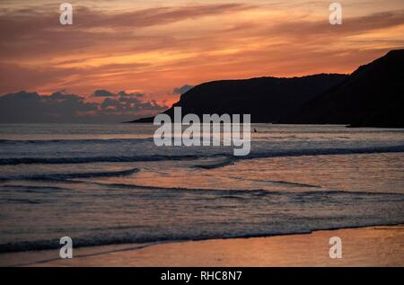 Swansea, Großbritannien. 01 Feb, 2019. Surfer die Wellen an Caswell Bay in der Nähe von Swansea heute Abend, wenn die Sonne am Ende eines kalten Wintern. Credit: Phil Rees/Alamy leben Nachrichten Stockfoto