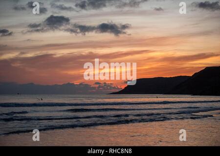 Swansea, Großbritannien. 01 Feb, 2019. Surfer die Wellen an Caswell Bay in der Nähe von Swansea heute Abend, wenn die Sonne am Ende eines kalten Wintern. Credit: Phil Rees/Alamy leben Nachrichten Stockfoto