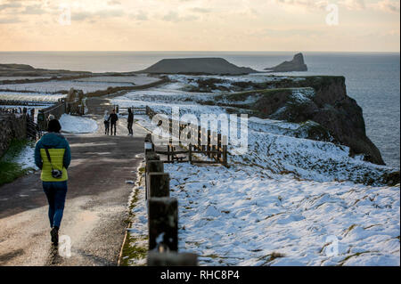 Swansea, Großbritannien. 01 Feb, 2019. Menschen gehen in Richtung zu den Würmern Landspitze im Rhossili auf der Halbinsel Gower in der Nähe von Swansea heute Nachmittag nach der Gegend war bedeckt mit Schnee. Credit: Phil Rees/Alamy leben Nachrichten Stockfoto