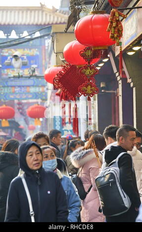 Peking, China. 2 Feb, 2019. Menschen gehen vorbei Spring Festival Dekorationen an der Wangfujing Straße in Peking, der Hauptstadt von China, Februar 2, 2019. Die Wangfujing Straße, einer der wohlhabendsten kommerziellen Zonen der Stadt, ist mit festliche Atmosphäre des Frühlingsfestivals gefüllt. Das Frühlingsfest oder das chinesische Mondjahr, fällt in diesem Jahr am 5. Credit: Li Xin/Xinhua/Alamy leben Nachrichten Stockfoto
