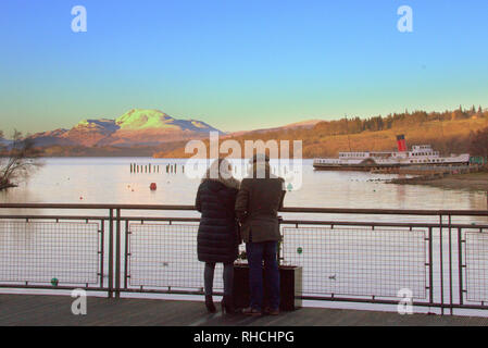 Glasgow, Schottland, Großbritannien, 2. Februar, 2019. UK Wetter: Temperaturen über Nacht und eine gelbe Warnmeldung für Eis. Loch Lomond über auf seiner Bonny Banken eingefroren war ein Eis Gefahr für Einheimische und Touristen, obwohl die Kinder spielten, die versuchen, das Eis mit Steinen zu brechen. Ben Lomond sah Erhabenen in der Sonne, die die niedrige Temperatur begleitet und wurde von allen bewundert. Kredit Gerard Fähre / alamy Leben Nachrichten Stockfoto