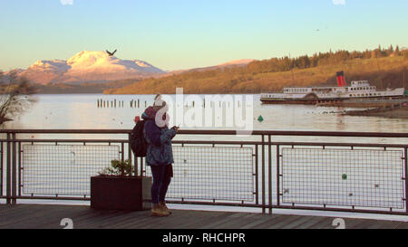 Glasgow, Schottland, Großbritannien, 2. Februar, 2019. UK Wetter: Temperaturen über Nacht und eine gelbe Warnmeldung für Eis. Loch Lomond Zufroren auf seiner Bonny Banken war ein Eis Gefahr für Einheimische und Touristen, obwohl die Kinder spielten, die versuchen, das Eis mit Steinen zu brechen. Ben Lomond erhabenen in der Sonne, die die niedrige Temperatur begleitet und wurde von allen bewundert. Kredit Gerard Fähre / alamy Leben Nachrichten Stockfoto