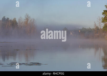 Im Herbst Nebel beginnt zu heben Sie enthüllt eine North Woods Home an den Ufern der Wildnis See in Nordwisconsin. Stockfoto