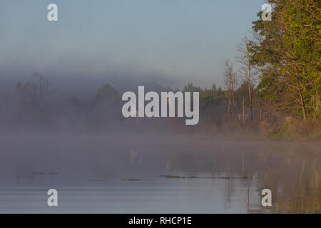 Im Herbst Nebel beginnt zu heben Sie enthüllt eine North Woods Home an den Ufern der Wildnis See in Nordwisconsin. Stockfoto