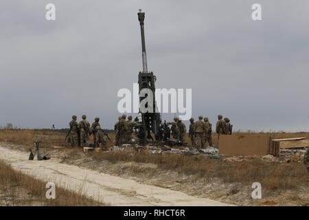 Fallschirmjäger in den zweiten Bataillon zugeordnet, 319 Airborne Field Artillery Regiment, 2nd Brigade Combat Team, 82nd Airborne Division mit einem M777 Haubitze auf Salerno Drop Zone während eines schweren drop" im Fort Bragg, North Carolina, Jan. 23, 2019. Die Funktion getestet Schwere der Brigade drop Beschäftigung für Zertifizierung und Validierung Verfahren während ihrer kombinierten Waffen Live Fire Übung (U.S. Armee Foto von SPC. Justin W. Stafford) Stockfoto