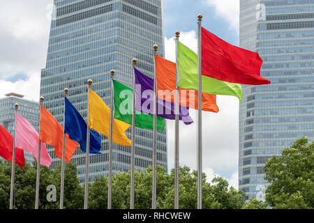 Verschiedene einfarbige Flags flyig aus einer Reihe von fahnenmasten in Shanghai, China Stockfoto
