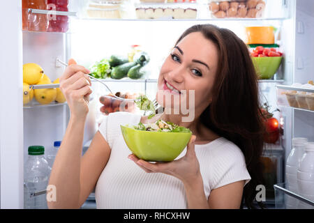 Portrait eines glücklichen jungen Frau Salat in der Schüssel Stockfoto