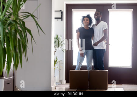 Gerne schwarz Paar Umarmung stehen im neuen Haus mit Boxen Stockfoto