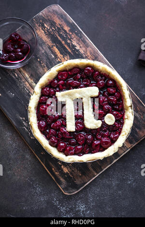 Pi-Tag Cherry Pie - Hausgemachter Kirschkuchen mit Pi-Zeichen für 14. März Urlaub, auf rustikalen Hintergrund, Ansicht von oben. Stockfoto