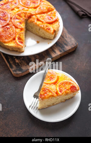 Nach oben orange Kuchen auf rustikalen Hintergrund. Hausgemachte Kuchen mit blutigen Orangen, Zitrusfrüchte. Stockfoto