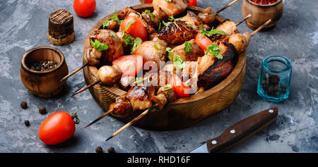 Chicken Kebab am Spieß mit Pilzen und Tomaten. Grill Fleisch auf Holzspieße Stockfoto