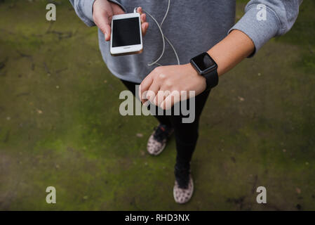 Junge Frau mit wearable Tech während Fitness Workout Stockfoto