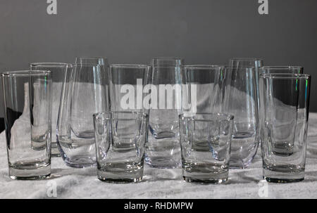 Interessantes Muster von Glas Trinkgläser, groß, klein, stemless, auf ein weißes Handtuch. Stockfoto