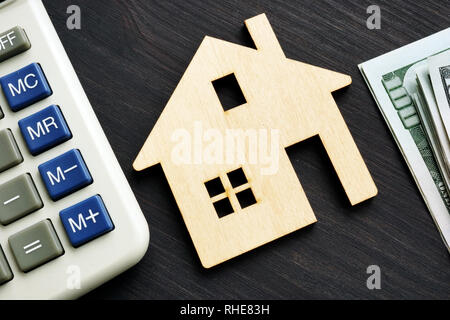 Home Wert. Holzhaus mit Taschenrechner und Geld. Stockfoto