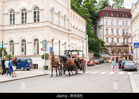 Karlsbad, TSCHECHISCHE REPUBLIK - 13. JUNI 2017: eine Pferdekutsche erwartet Touristen am Ufer des Flusses Tepla. Stockfoto