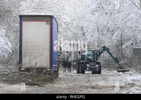 Ein Lkw steht als Arbeiter klar Bäume, die durch das Gewicht der Schnee, von Walderslade Woods Road, in Walderslade, Kent, von der erwartet wird, dass sie das ganze Wochenende geschlossen werden aufgegeben. Autofahrer wurden für eine zweite Nacht gestrandet als schweren Schnee bedeckten Straßen und Das winterliche Wetter Verkehr zum Stillstand gebracht. Stockfoto