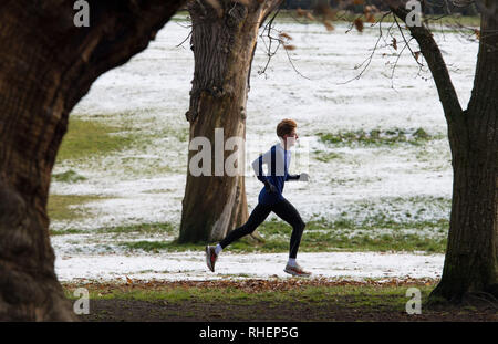 Ein Läufer in Greenwich Park, im Süden Londons, nach Schneefällen gestern und über Nacht werden voraussichtlich weit verbreiteten Störungen zu bringen. Stockfoto