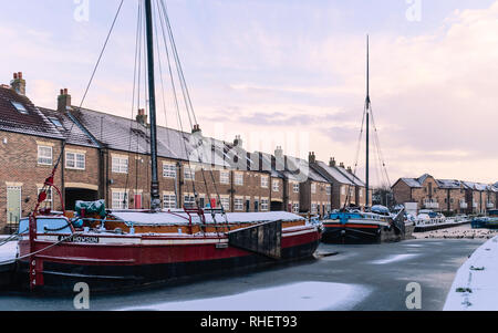 Vintage Lastkähne günstig entlang der gefrorenen Beck (Kanal) und im Schnee durch die Stadt Häuser im Winter in Beverley, Yorkshire, UK flankiert. Stockfoto