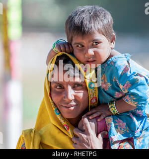 Porträt einer Rajasthani Mutter mit einem Kind in Ranthambore. Rajasthani Menschen sind als einige der schillerndsten Menschen in Indien bekannt. Stockfoto