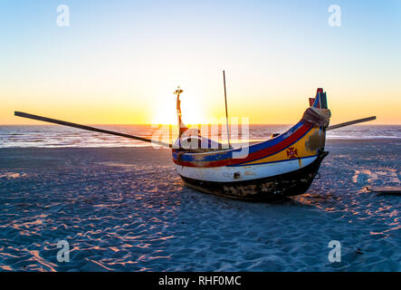 Fischerboot am Strand. Sonnenuntergang auf dem Meer. Portugal. Stockfoto