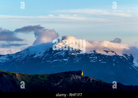 Berglandschaft. Gipfel mit Schnee im abendlichen Sonnenlicht und eine Wolke oben. Sommer in Georgien. Stockfoto