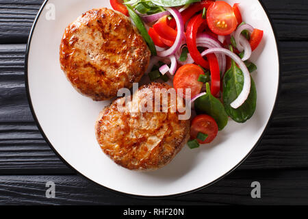 Lecker Frikadellen crepinette in einem ñaul Fett und frisches Gemüse Salat close-up auf einem Teller gewickelt. horizontal oben Ansicht von oben Stockfoto