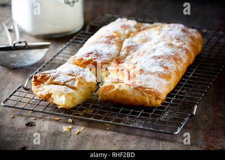 Hausgemachte griechische Vanillepudding Torte mit Puderzucker und Zimt Stockfoto