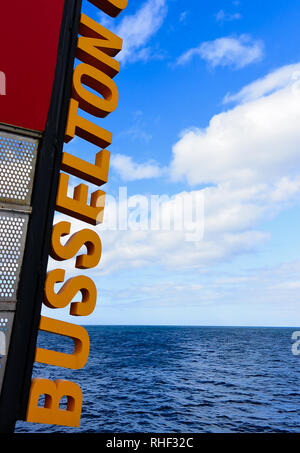 Einfache Aufnahme von 3D-gelbe Buchstaben altes Schild an der berühmten Busselton Jetty im Süden WA, mit viel kopieren Platz auf dem blauen Meer und bewölkter Himmel Hintergrund Stockfoto