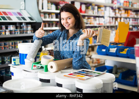 Mädchen 18-25 Jahre alt ist Einkauf Werkzeuge für Haus Verbesserungen in Farbe liefert. Stockfoto
