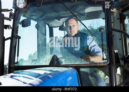 Portrait von zuversichtlich Mann im Weinberg in der Traktorkabine Sitzen arbeiten Stockfoto