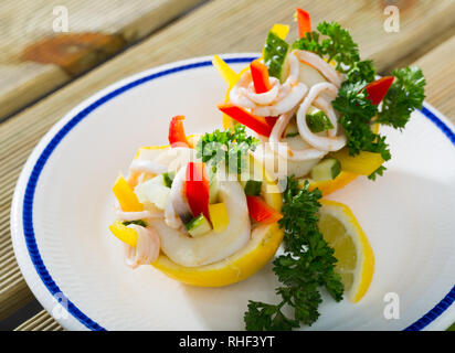 Köstliche Meeresfrüchte und Gemüse Salat mit Tintenfischen, Gurken, Paprika mit Olivenöl und griechischen Joghurt Dressing Stockfoto