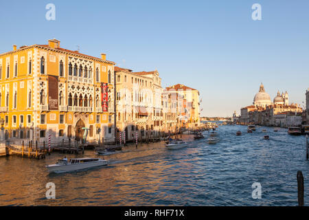 Grand Canal bei Sonnenuntergang mit Blick Vergangenheit Palazzo Cavalli-Franchetti zur Basilika Santa Maria della Salute mit Schiffsverkehr, Venedig, Venetien, Italien Stockfoto